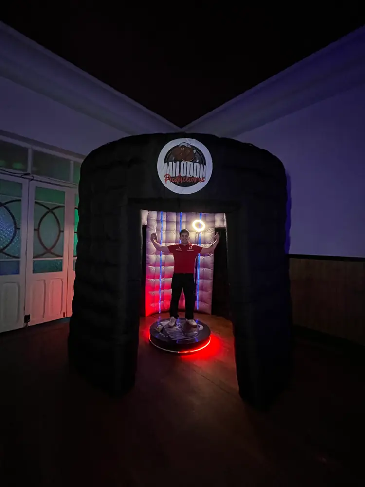 Cabina espejada iluminada por dentro durante un evento