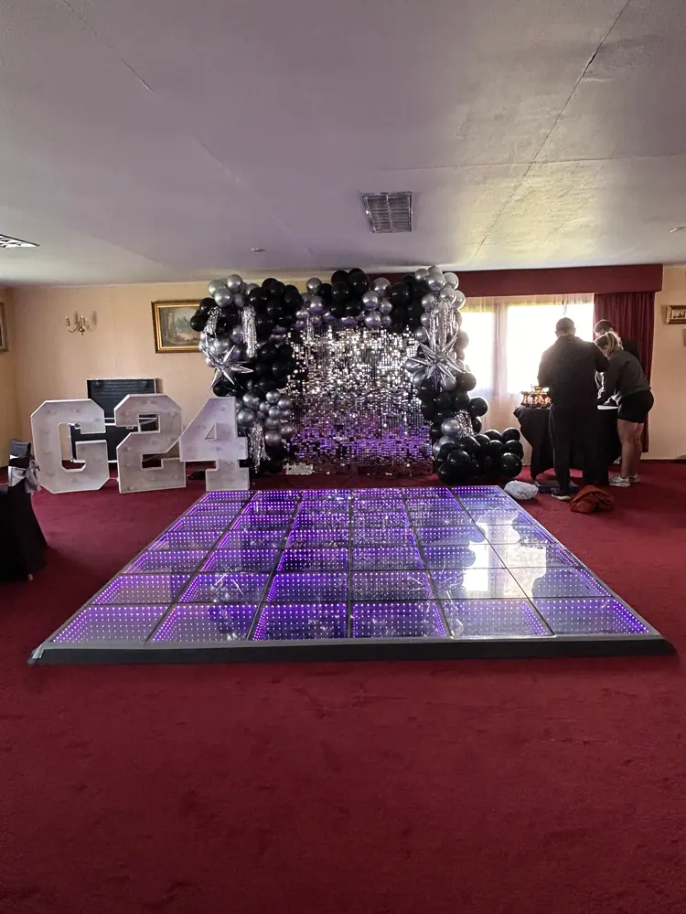 Pista LED Infinity encendida en un salón con decoración de globos