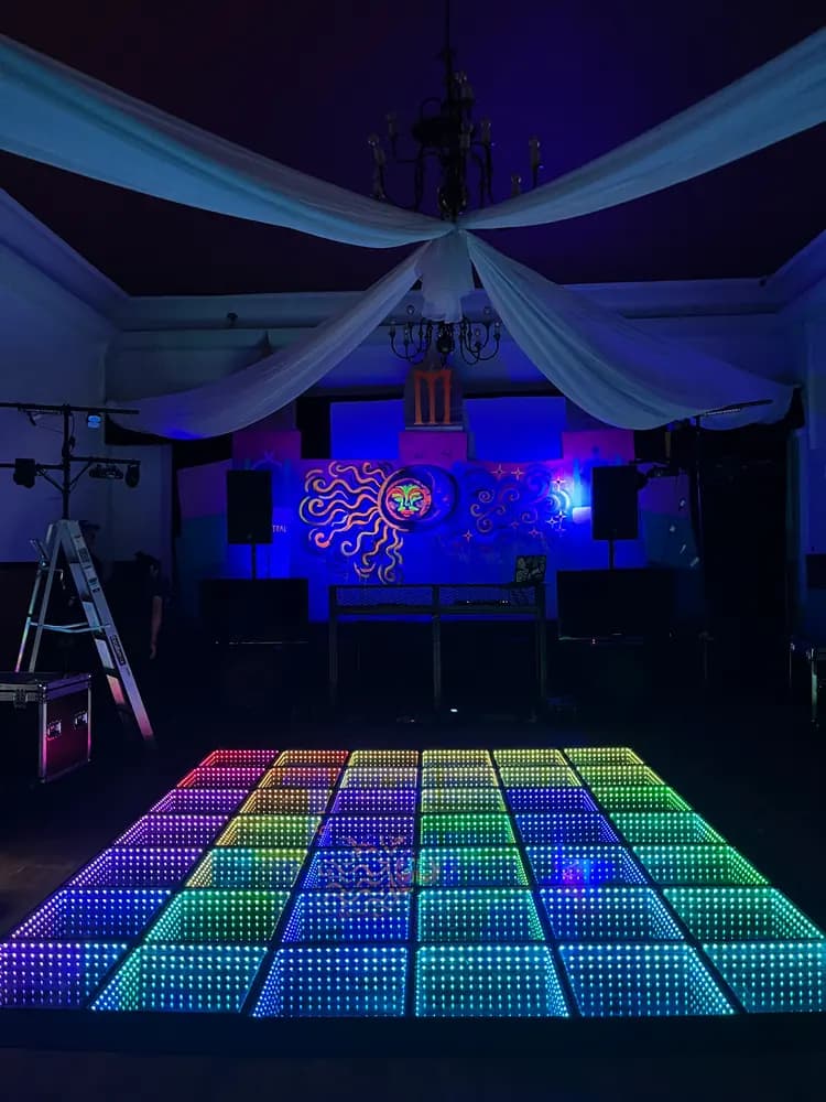 Pista LED Infinity de colores con escenario iluminado al fondo